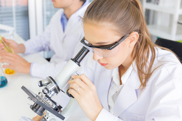 Poster - Male and female scientists working in a science laboratory with various equipment in the laboratory.