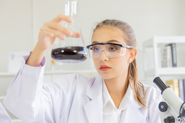 Poster - A beautiful female scientist is operating in a science lab with various equipment in the lab.