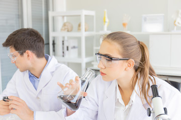 Poster - Male and female scientists working in a science laboratory with various equipment in the laboratory.