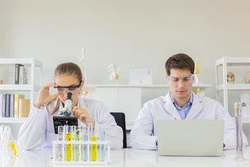 Poster - concept of a healthcare researcher, a researcher working in a life science lab, a young research scientist and a male supervisor preparing and analyzing microscopic slides in a research laboratory