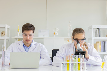 Poster - concept of a healthcare researcher, a researcher working in a life science lab, a young research scientist and a male supervisor preparing and analyzing microscopic slides in a research laboratory