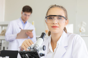 Poster - The concept of a new generation of scientific researchers looking through a microscope in a laboratory Young scientists are doing research.