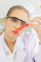Poster - A beautiful female scientist is operating in a science lab with various equipment in the lab.