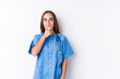 Young nurse woman isolated looking sideways with doubtful and skeptical expression.