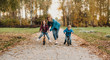 © Strelciuc - Charming caucasian mother with two kids who are riding joyfully the bike in the park during a walk