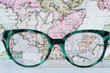 Eyeglasses Glasses with Bifocals and Black Blue Frame smudged  Fashion Vintage Style on Wood Desk with world map background. 