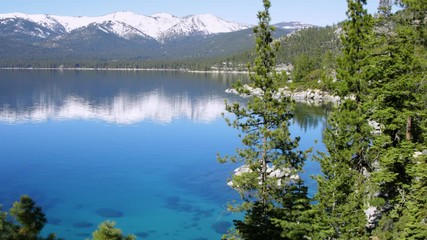 Wall Mural - Turquoise waters of Lake Tahoe in spring with snowy peaks of Sierra Nevada mountains, 4k