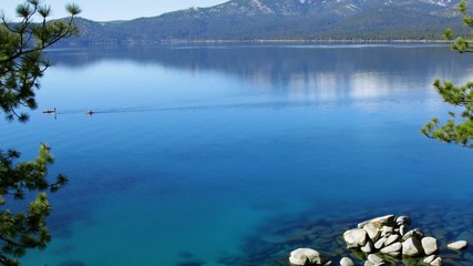 Wall Mural - Paddle boarding and kayaking across turquoise waters in Lake Tahoe, 4k