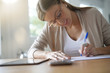 © goodluz - Portrait of woman writing on document