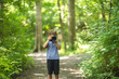 © digitalskillet1 - Young boy taking photo in the forest.