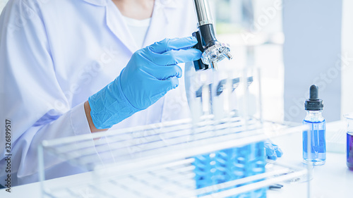 Fotografía Medical or scientific researcher or man doctor looking at a test tube of clear s