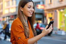 Happy Beautiful Young Woman Using Smart Phone For Video Call Outdoor With Blurred Background Of City Street, Selective Focus. City Lifestyle People Technology.