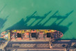 © Юлия Корниевич - A bulk carrier stands at the berth of a coal terminal in the seaport, cargo is being loaded from an open warehouse onto a ship with a conveyor belt and a ship loading machine.