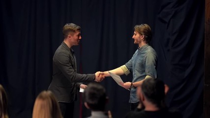 awarding a certificate on stage is applauded