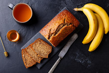Banana, Coconut Bread, Cake With Cup Of Tea On Slate Board. Dark Stone Background. Copy Space. Top View.