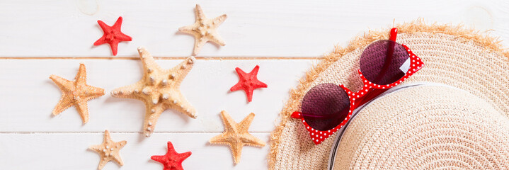 Beach hat with seashells on brown banner wooden table. summer background concept with copy space top view