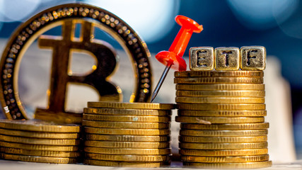 Bitcoin coin and a pile of gold coins  and red pin with ETF text , Concept Entering the Digital Money Fund.