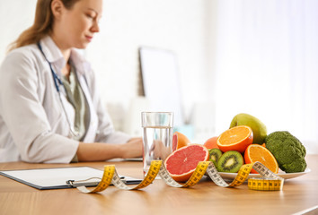 Wall Mural - Healthy products, measuring tape and blurred nutritionist on background