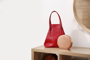 Different stylish woman's bags on wooden shelf