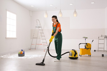 Canvas Print - Professional janitor cleaning room with vacuum after renovation