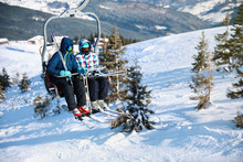 People Using Chairlift At Mountain Ski Resort, Space For Text. Winter Vacation
