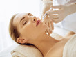 © rogerphoto - Beautiful woman receiving beauty injections with closed eyes. Beautician doctor hands doing beauty procedure to female face with syringe. Cosmetic medicine and surgery concept