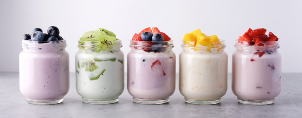 Variety of yogurts in glass jars. Healthy Breakfast Concept. Banner Photography