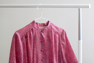 Purple floral vintage dress on a clothing rack. Selective focus.