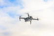 © Niko_Dali - Small gray drone flying in the sky, quadcopter on a cloudy sky background.