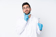 © luismolinero - Dentist man holding tools isolated on white background thinking an idea