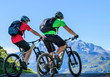Zwei Mountainbiker radeln vor imposanter Gebirgskulisse