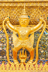 Wall Mural - The Golden Garuda and Naga Statue Decorated with colored glass On the wall of the Buddhist temple at Emerald Buddha Temple And the royal palace Bangkok, Thailand