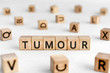 Tumour - words from wooden blocks with letters, a mass of diseased cells tumour concept, white background
