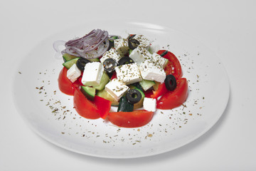 Fresh salad with vegetables and cheese on a white background