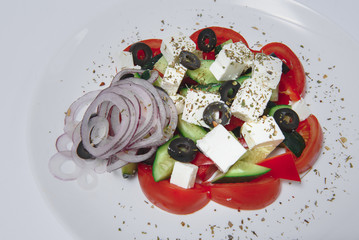 Fresh salad with vegetables and cheese on a white background