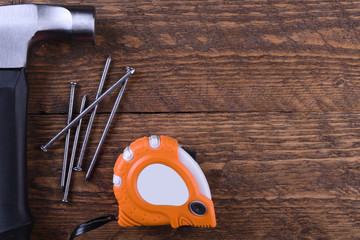 Poster - Hammer iron,centimeter tape and nails on wooden background