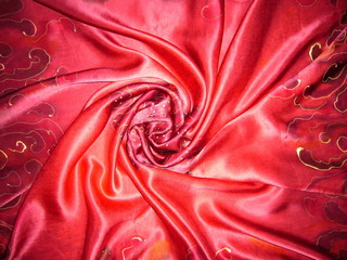 Red silk fabric with drapery. The texture of the fabric. Natural silk. Silk scarf, silk scarf.