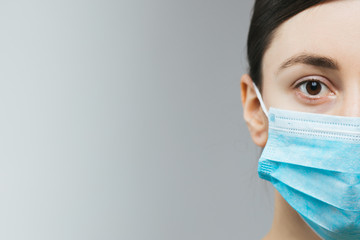 Woman with brown hair and a medical mask for protection again influenza. Copy space for your text. Woman with arms outstretched forward