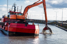 Dredger Ship At Work In East Neuk Harbour, East Coast Of Scotland
