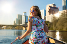 Happy, joyful, cheerful young woman in sunglasses enjoying a hot summer day with water activities, boating, kayaking, and canoeing in Austin Texas