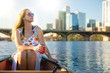 © elnariz - Beautiful woman on a summer day enjoying a relaxing boat ride on lake in american city on a sunny day, recreational lifestyle