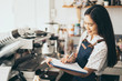 © Have a nice day  - Asian women waiter hands on notebook, taking customer orders in restaurant or cafeteria, Thai girl coffee shop worker wearing apron write order serving for a client, writing food list service concept
