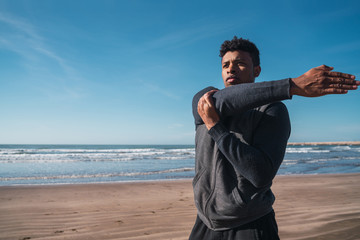 Athletic man stretching arms before exercise.