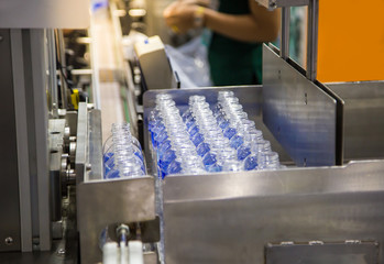 Poster - Production line collecting empty plastic bottle from blowing machine before packing in plastic bag