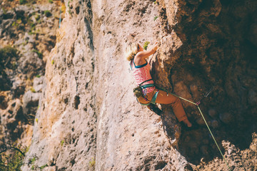 Wall Mural - A girl climbs a rock.