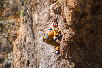 Wall Mural - A girl climbs a rock.