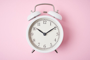 Wall Mural - White retro alarm clock on the pink background with copy space. Time concept