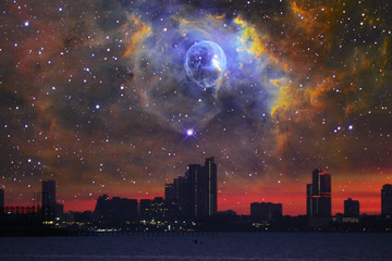 Wall Mural - Nebula in galaxy over silhouette building on and city night sky