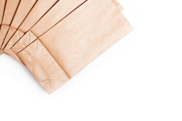 A few simple small tiny eco friendly new disposable brown paper bags set background Saving the environment by using an ecological paper food packaging bag containers concept isolated on white top view