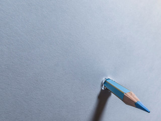 Pencil punching a sheet of paper